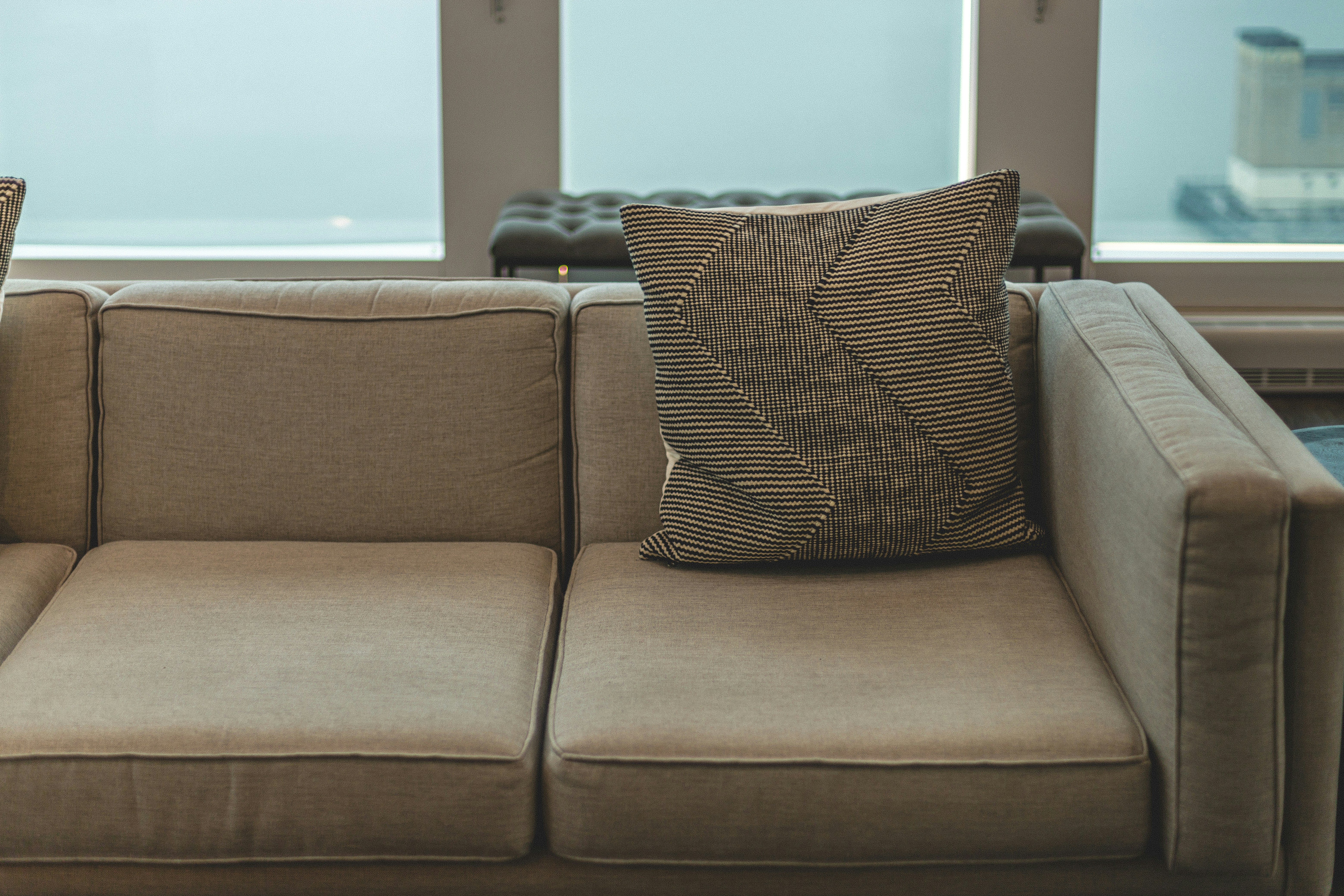brown and black throw pillow on brown sofa